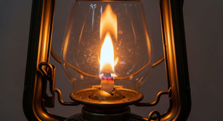 Burning candle in a vintage oil lamp, close-up.