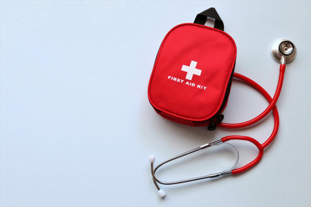 First aid kit with stethoscope on white background, top view
