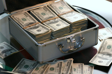 Money in a metal case on a black background. Business concept.