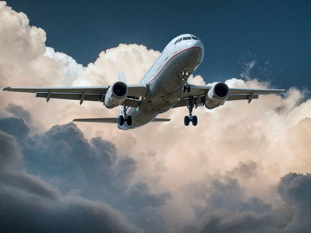 Airplane flying in the blue sky with white clouds on the background