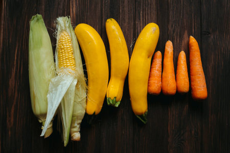 Vegetables on a wooden background. Yellow, orange and green carrots.
