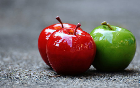 Red and green apples on a gray background. Shallow depth of field.