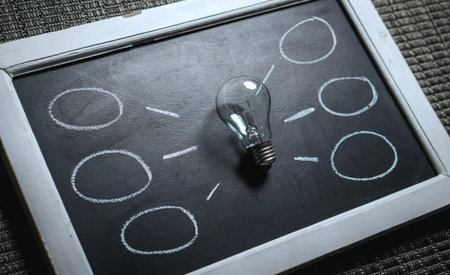 Conceptual image of business ideas with lightbulb on chalkboardの写真素材