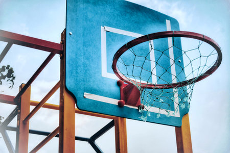 Basketball hoop on blue sky background. Vintage tone filter effect color style.