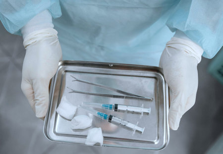 Close-up of doctors hands holding syringes and ampoules