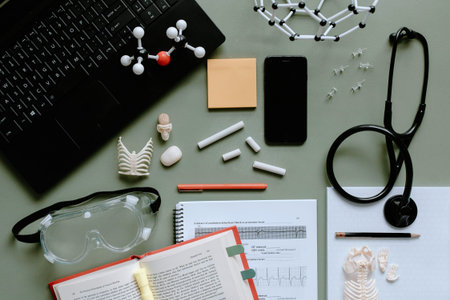Flat lay of doctor workspace with stethoscope, computer and medical equipment.
