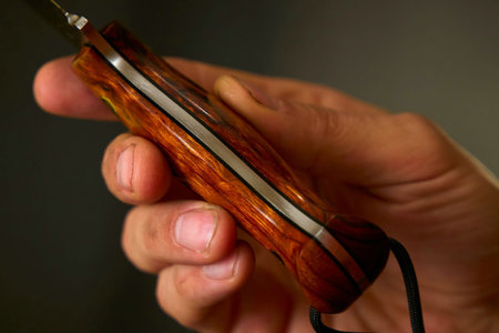 Close up of a caucasian man holding a wooden hunting knife