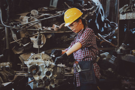 Engineer woman working in car repair shop. Female car mechanic at work.
