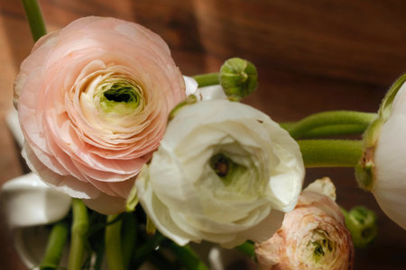 Beautiful ranunculus flowers bouquet on a wooden background.