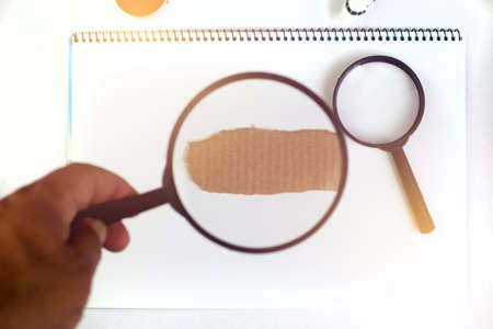hand holding magnifying glass over note book. searching conceptの写真素材