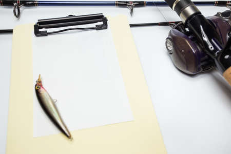 fishing rod and fishing lure on blank paper noteの写真素材