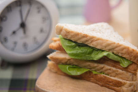 sandwich and glass of fresh milk on cutting boardの写真素材