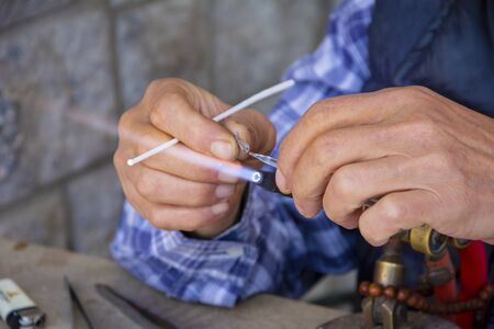 Glass artist shapes the material in his hand with fireの写真素材