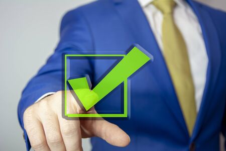 business man touching check mark on virtual screen with handの写真素材