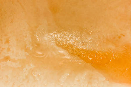 Dirty, rusty water on the surface of a sink or bath background.の写真素材