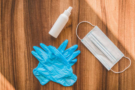 Antiseptic, protective gloves and medical mask on table background.の写真素材