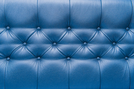 Blue leather upholstery sofa with pattern button design furniture style decor texture background.の写真素材