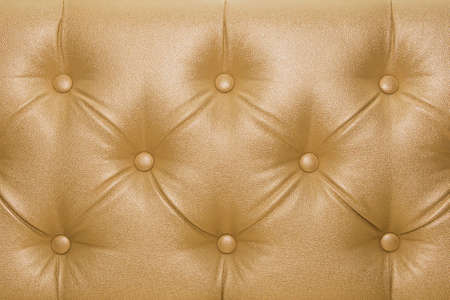 Yellow or gold leather upholstery sofa with pattern button design furniture style decor texture background.の写真素材