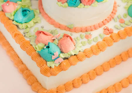 Part of the festive color cake with cream and roses flowers close-up.の写真素材