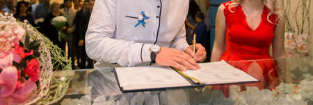 Witness's hands at wedding sign, close up.の写真素材