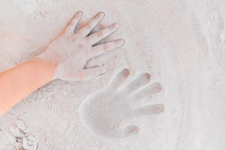 Trace or handprint of a young girl close up on the white beach sand background.の写真素材