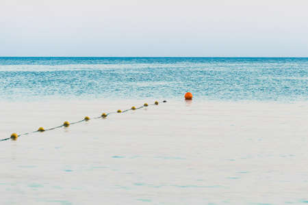 Limiting swimming buoys on the sea background in the evening.の写真素材