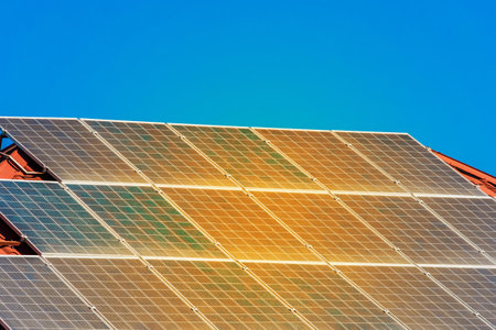 Solar panels on the roof of a building against a blue sunny sky.の写真素材