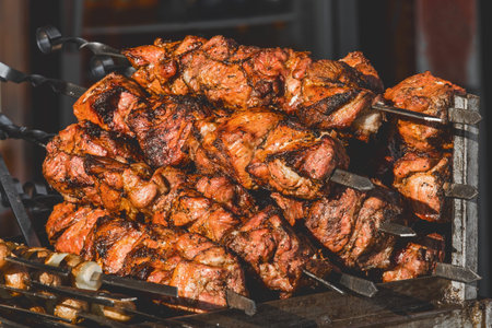 Fried kebab meat on skewers in a street establishment, close-up.
