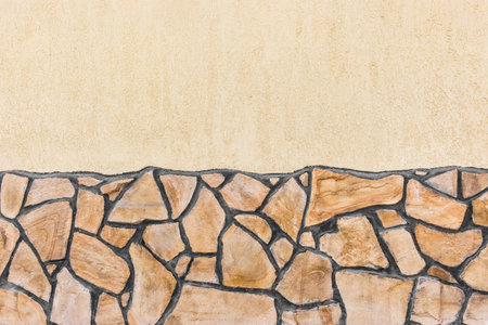 Facade of modern building with beige plaster wall and stone pattern texture exterior background.