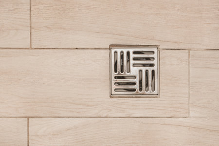 Floor drain, metal hole for draining water in the shower cabin in the bathroom, top view.の写真素材