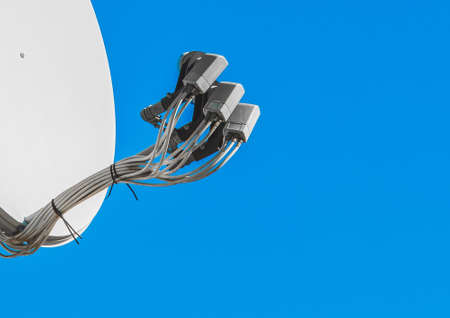 Feedhorn of a satellite dish against a blue sky, close-up.の写真素材