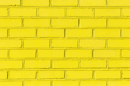Yellow paint bright light brick old city wall texture background.の写真素材