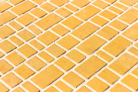 Light orange or yellow stone paving slabs floor tile urban texture background.の写真素材