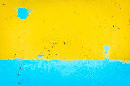 Yellow and blue peeling paint on old color art texture design wall artwork background.