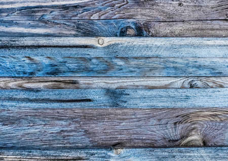 Dark gray texture of an old wooden fence with blue paint, abstract plank background.の写真素材