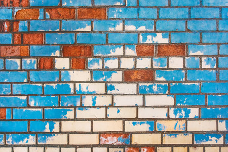 Old dirty colored brick wall texture with blue peeling paint background.の写真素材
