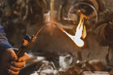Gas burner with burning flame close up on the background of an industrial workshop.の写真素材