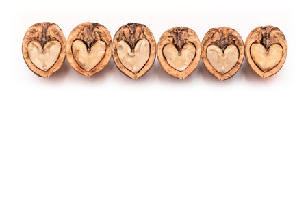 Walnut in a cut halves in the form of a heart isolated on a white background, copy space or mock up...