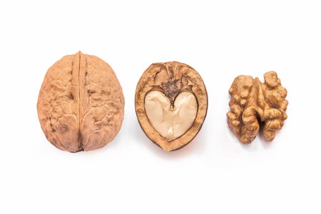 Different forms and areas of walnut. Walnut half in the form of a heart and peeled nut on a white...