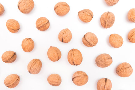 Heap of whole walnuts in the shell isolated on white background.の写真素材