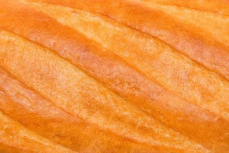 Fresh long loaf texture bakery background, close-up.