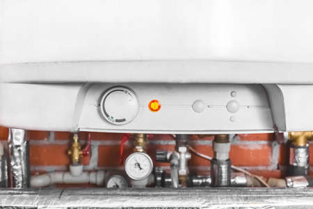 A boiler and a pipe system with water heating equipment and a gauge at an industrial plant in the workshop.の写真素材