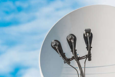 Feedhorn of a satellite dish against a blue sky, close-up.の写真素材