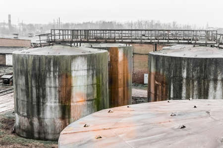 Old fuel oil tanks with fuel oil stains and traces of rust at an abandoned industrial plant.の写真素材