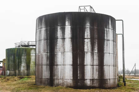 Old fuel oil tanks with smudges of fuel oil in an abandoned industrial plant.の写真素材