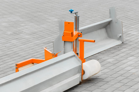 Part of industrial equipment for leveling hard-surfaced surfaces against the background of paving...
