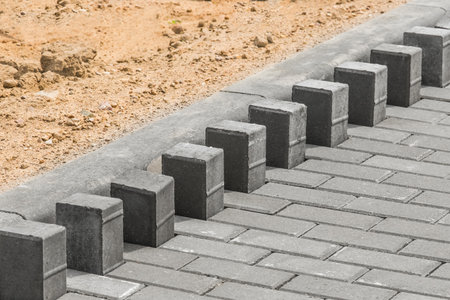 Laying floor tile sidewalk urban road or repairing paving stone slabs at a construction site.の写真素材