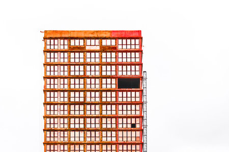 Unfinished construction of concrete city house against gray sky.