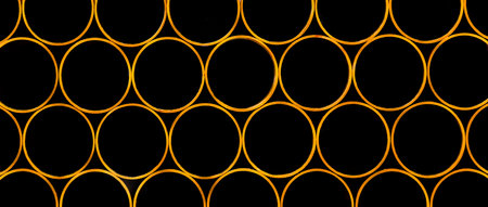 Pile of round industrial material polyethylene thermoplastic pipes on a construction site.の写真素材