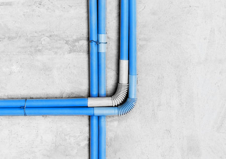 Plastic PVC pipe insulation on construction concrete home wall repair.